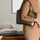 Modelo mostrando el bolso Mikado Bronce, elegante y sostenible.