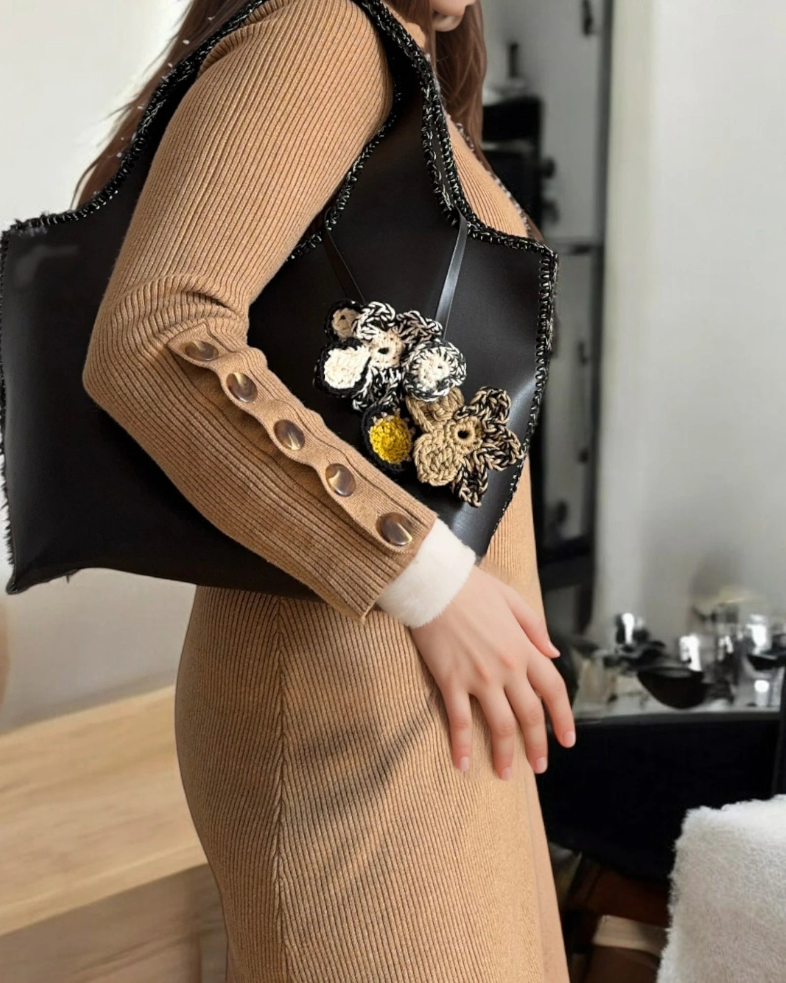 Modelo sosteniendo el Mikado Negro con look urbano chic.